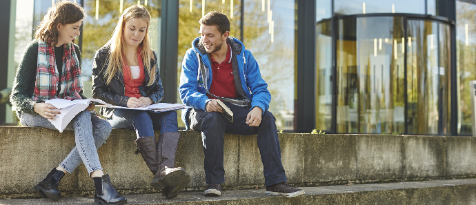 A trio of students sat on some stairs on campus.